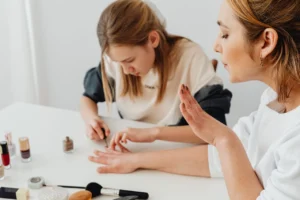 Profissional realizando procedimento de manicure ou cuidados com as mãos de uma mulher, capturando aspectos de beleza e bem-estar em uma atmosfera relaxante.