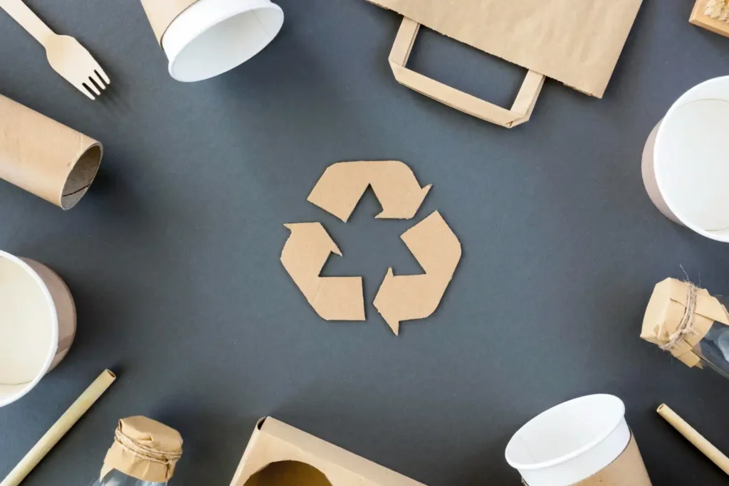 Embalagens industriais recicláveis para produtos sustentáveis e diferenciais de marca, incluindo caixas, copos e embalagens de papel reciclado em ambiente de reciclagem.