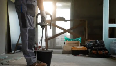 Profissional aplicando tinta impermeabilizante no piso durante uma reforma, ideal para áreas que precisam de proteção contra umidade. Saiba quando usar.